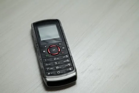 Old cellular device placed on the table top in the home office, showing the s Stock Photos
