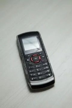 Old cellular device placed on the table top in the home office, showing the s Stock Photos