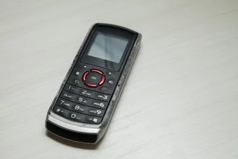 Old cellular device placed on the table top in the home office, showing the s Stock Photos