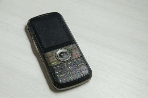 Old cellular device placed on the table top in the home office, showing the s Stock Photos