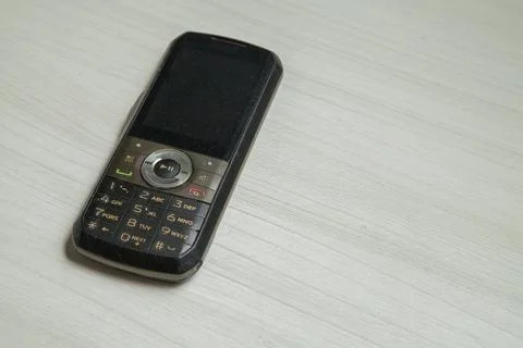 Old cellular device placed on the table top in the home office, showing the s Stock Photos