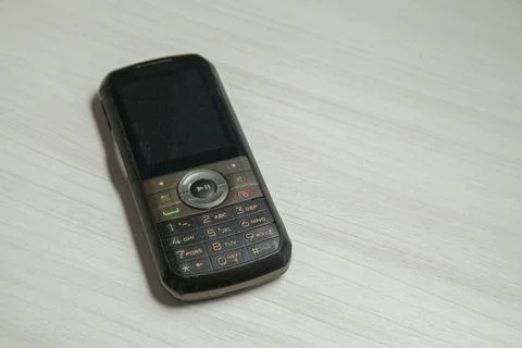Old cellular device placed on the table top in the home office, showing the s Stock Photos