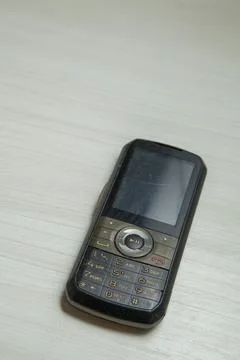 Old cellular device placed on the table top in the home office, showing the s Stock Photos