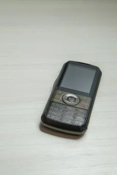 Old cellular device placed on the table top in the home office, showing the s Stock Photos