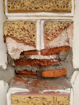 Old cement posts that had been broken over time to see the red bricks inside. Stock Photos