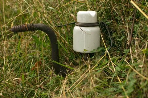 An old ceramic insulator abandoned in the grass Stock Photos