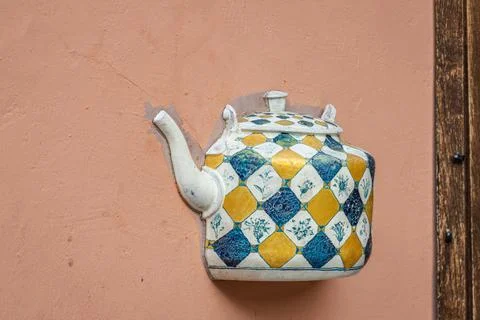 Old ceramic teapot embedded in a painted plastered wall Stock Photos