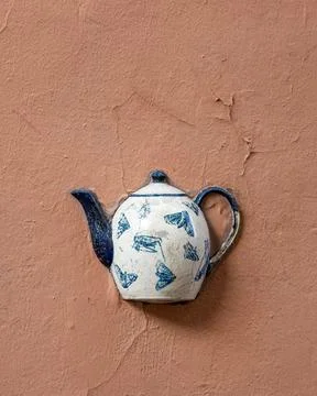 Old ceramic teapot embedded in a painted plastered wall Stock Photos