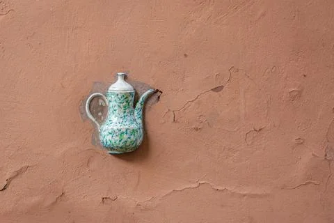 Old ceramic teapot embedded in a painted plastered wall Stock Photos