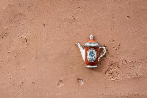 Old ceramic teapot embedded in a painted plastered wall Stock Photos