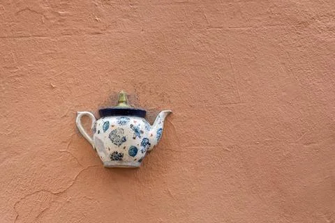 Old ceramic teapot embedded in a painted plastered wall Stock Photos