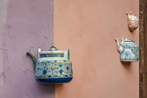 Old ceramic teapots embedded in a painted plastered wall Stock Photos