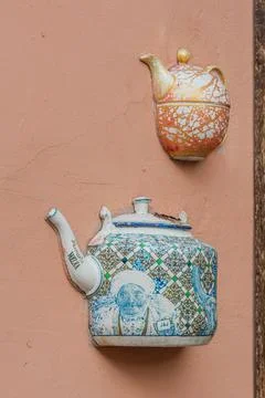 Old ceramic teapots embedded in a painted plastered wall Stock Photos