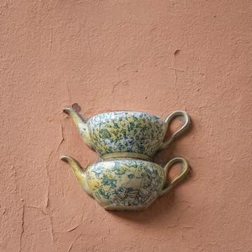 Old ceramic teapots embedded in a painted plastered wall Stock Photos