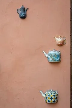 Old ceramic teapots embedded in a painted plastered wall Stock Photos