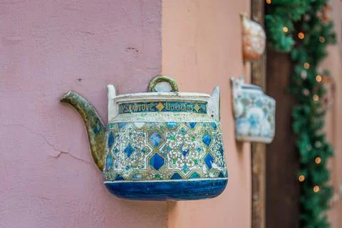 Old ceramic teapots embedded in a painted plastered wall Stock Photos