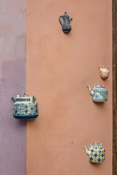 Old ceramic teapots embedded in a painted plastered wall Stock Photos