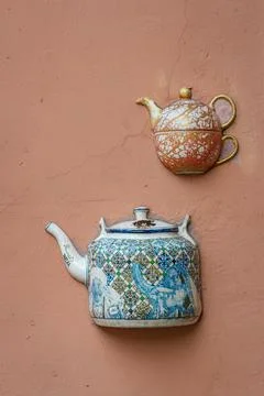 Old ceramic teapots embedded in a painted plastered wall Stock Photos
