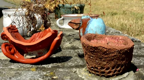 Old ceramics objects stand on the brick wall  in the countryside Stock Footage 61515589