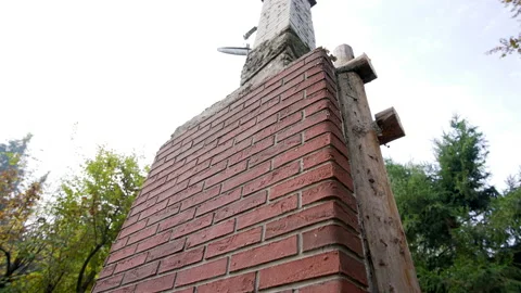 Old chimney made of red bricks standing in garden Stock Footage 158975043