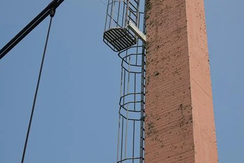 Old chimney stack in daytime with attached steel ladder for maintenance acces Fotos de archivo