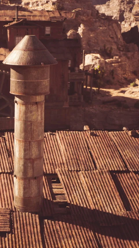 Old chimney stands over weathered buildings in a historic mining town Stock Footage 339044704