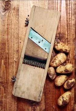 Old chip maker with fresh potatoes Stock Photos