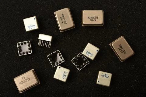 Old chips on a black background. Microchips on foam rubber. Microcircuits. Stock Photos
