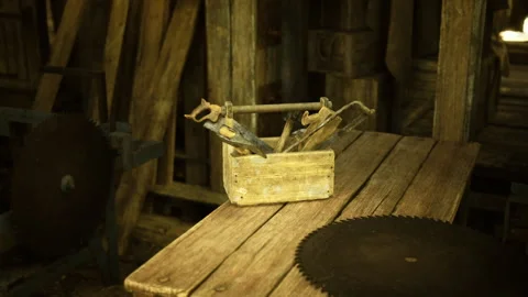 Old circular saw and toolbox set on weathered wooden surface with moody glow Stock Footage 340663473