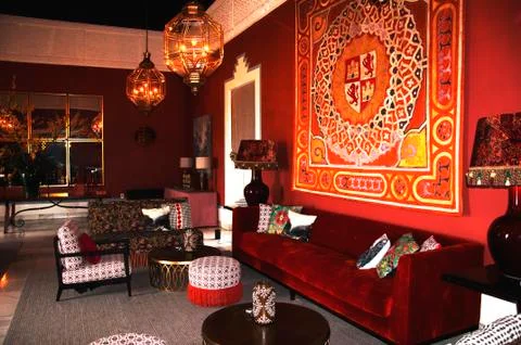 Old classical spanish interior with big red velvet sofa and carpet on the wal Stock Photos
