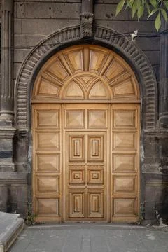 Old classical stone house with rustic, brown, carved, vintage wooden door. Door Stock Photos