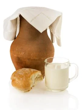 Old clay jug, bread and a mug of milk Foto stock