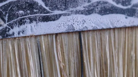 An old but clean flat paint brush made of mixed bristles. Extreme close-up, real Stock Footage 129149154