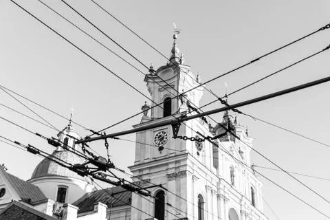 The old clock on the tower behind a bunch of wires Stock Photos