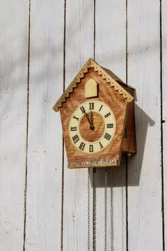 Old clock on a wooden light wall. Vintage clock. Stock Photos