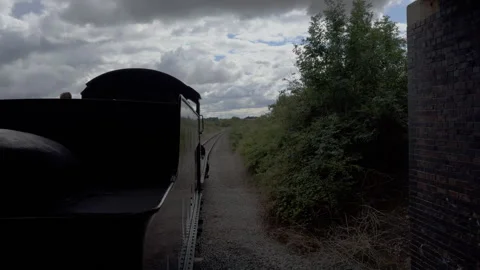 Old coal steam train travels through English countryside with smoke billowing Stock Footage 333205536