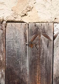Old cob wall with cracked surface and old wooden boards Stock Photos