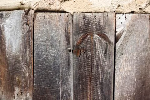 Old cob wall with cracked surface and old wooden boards Stock Photos