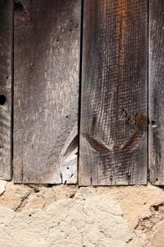 Old cob wall with cracked surface and old wooden boards Stock Photos