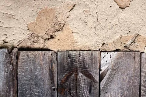 Old cob wall with cracked surface and old wooden boards Stock Photos