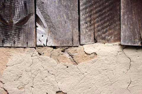 Old cob wall with cracked surface and old wooden boards Stock Photos