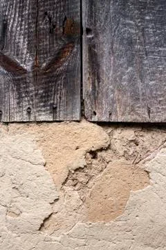 Old cob wall with cracked surface and old wooden boards Stock Photos