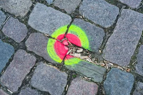 Old cobblestone marking with yellow ring and pink center. Stock Photos