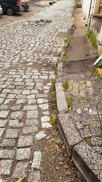 Old Cobblestone Street Path with Stone Curb and Green Grass. Stock Photos