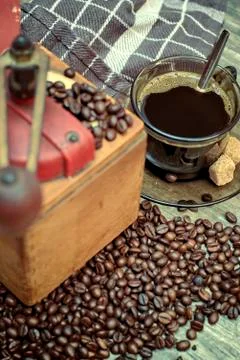 Old coffee grinder with a cup of coffee. Stock Photos