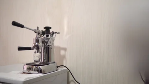 Old coffee machine is stoin on the table against the white wall and brews coffee Stock Footage 92375395