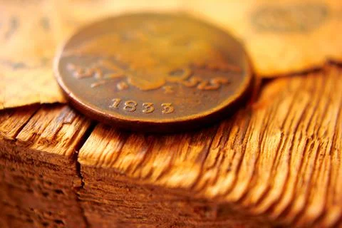 Old coin close-up on an old table, macro focus on a coin Stock Photos
