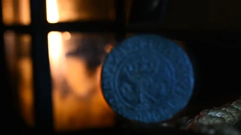 Old Coin Ilumined by candlelight in the Background Stock Footage 333609741