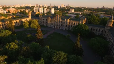 Old colledge on the background of the city at sunset aerial Stock Footage 104711359