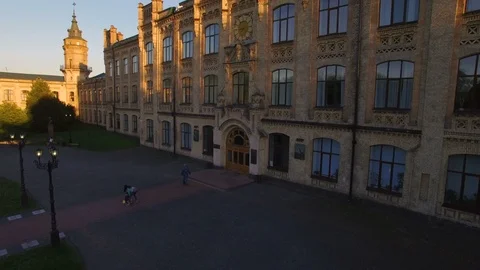 Old colledge on the background of the city at sunset aerial Stock Footage 104713041
